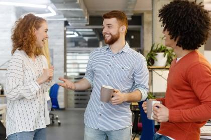 Drie collega's lachen met elkaar onder het genot van een kop koffie - Nestlé Professional