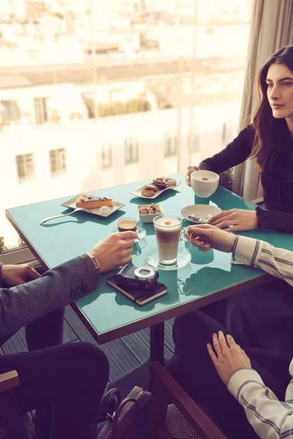Drie personen drinken samen een kop koffie bij het raam - Nestlé Professional