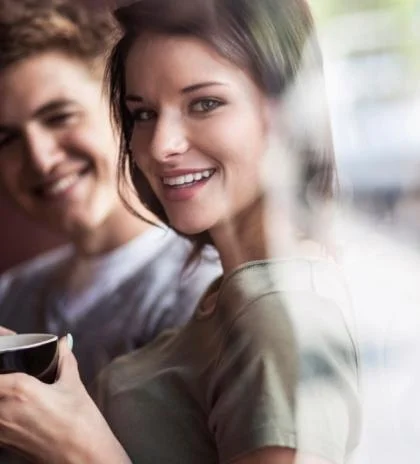 Man en vrouw met kop koffie kijken lachend in de camera - Nestlé Professional
