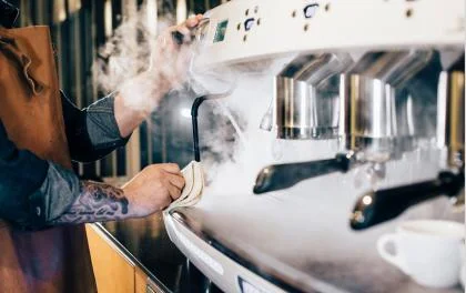 Barista maakt een rokende koffiemachine schoon - Nestlé Professional