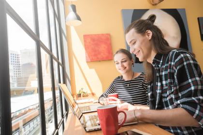 Twee personen werken bij het raam en drinken lachend koffie - Nestlé Professional