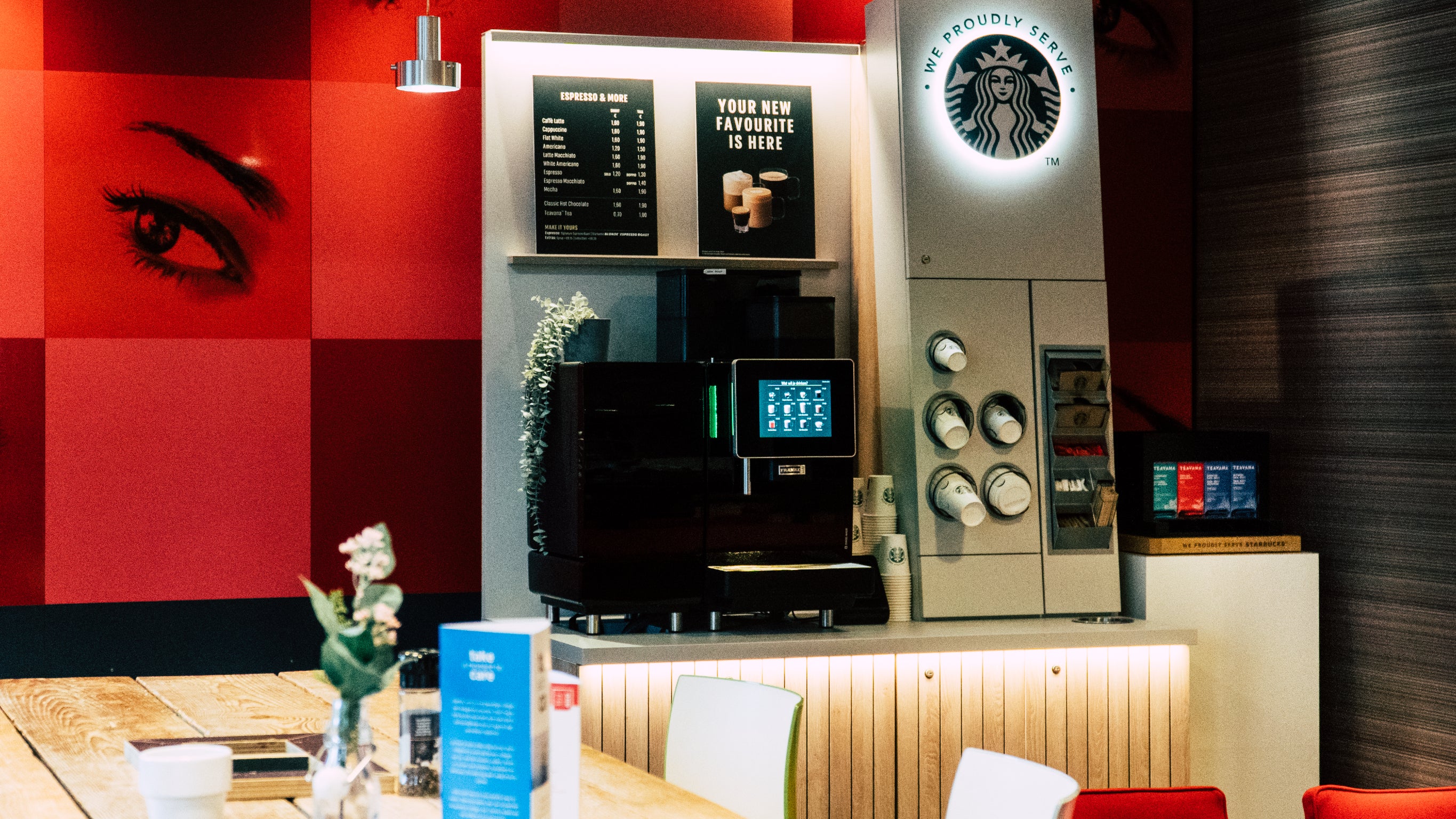 Kantine met rode muur met starbucks koffiezetapparaat - Nestlé Professional