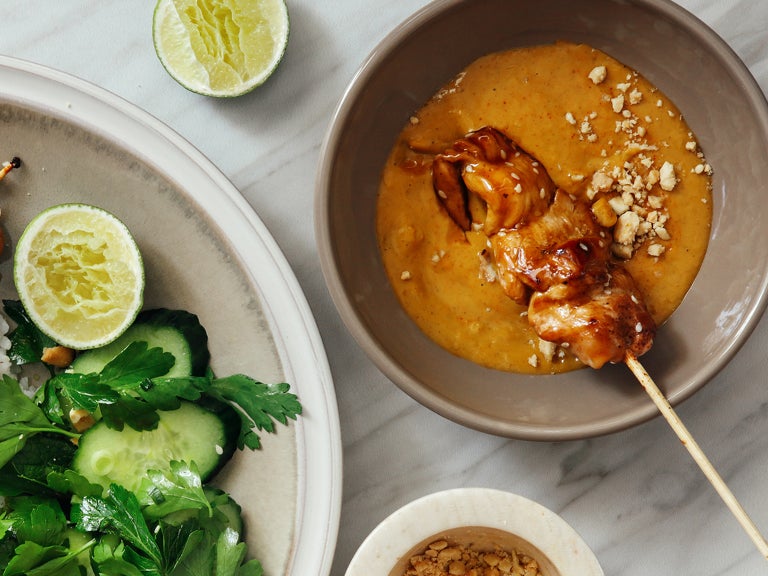 Bovenaanzicht van saté met satésaus en een bord met salade - Nestlé Professional