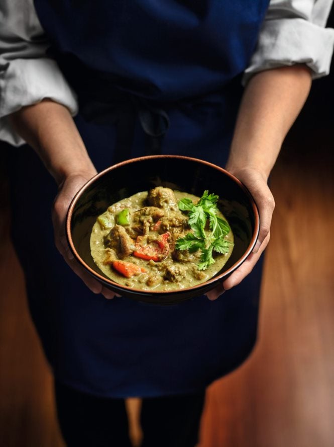 Handen houden een bord met curry vast - Nestlé Professional