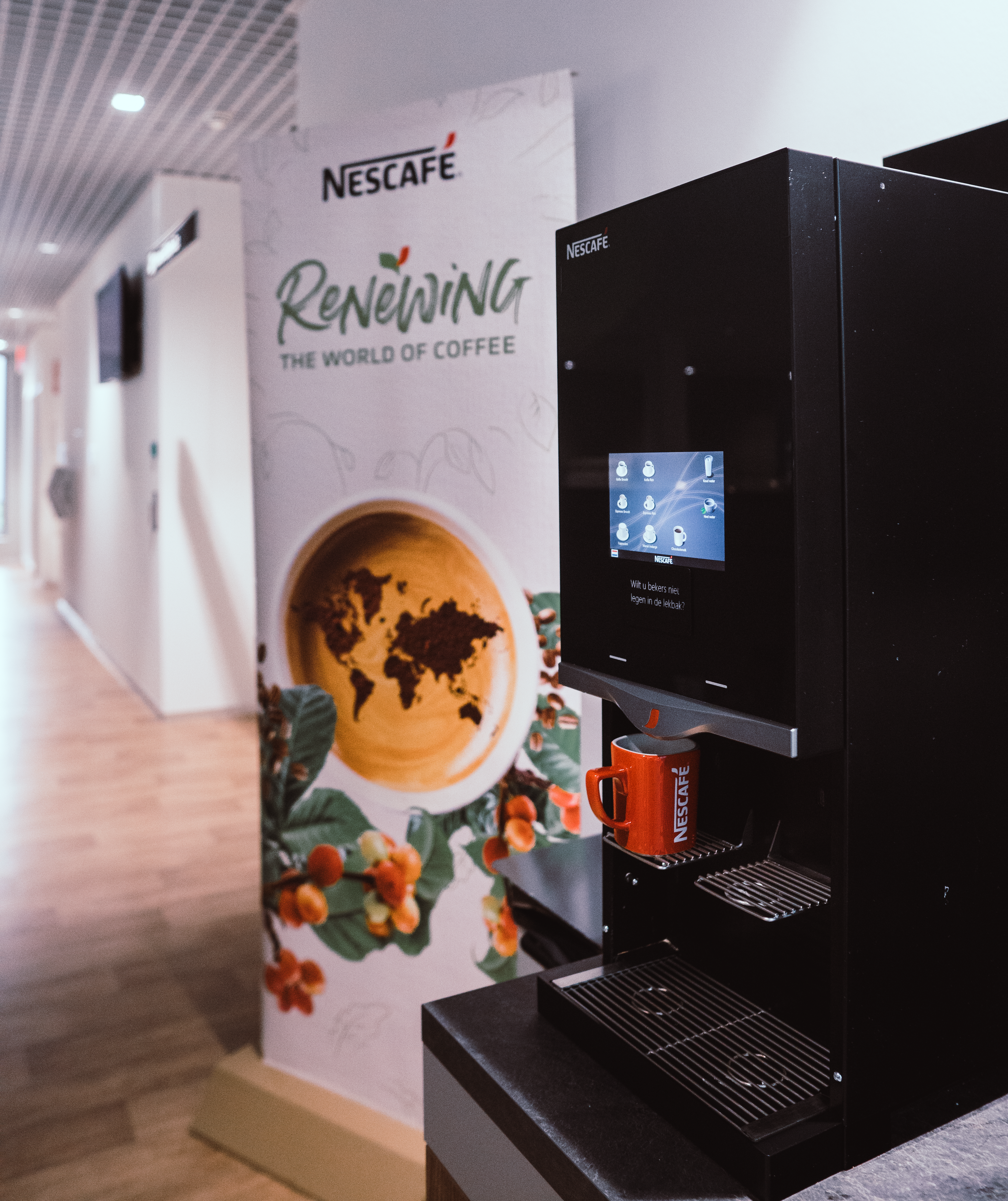 Nescafé koffiezetapparaat met Renewing banner op de achtergrond - Nestlé Professional
