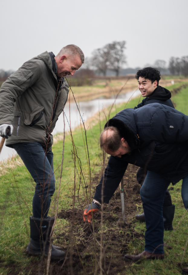 Drie mannen planten bomen langs een rivier - Nestlé Professional