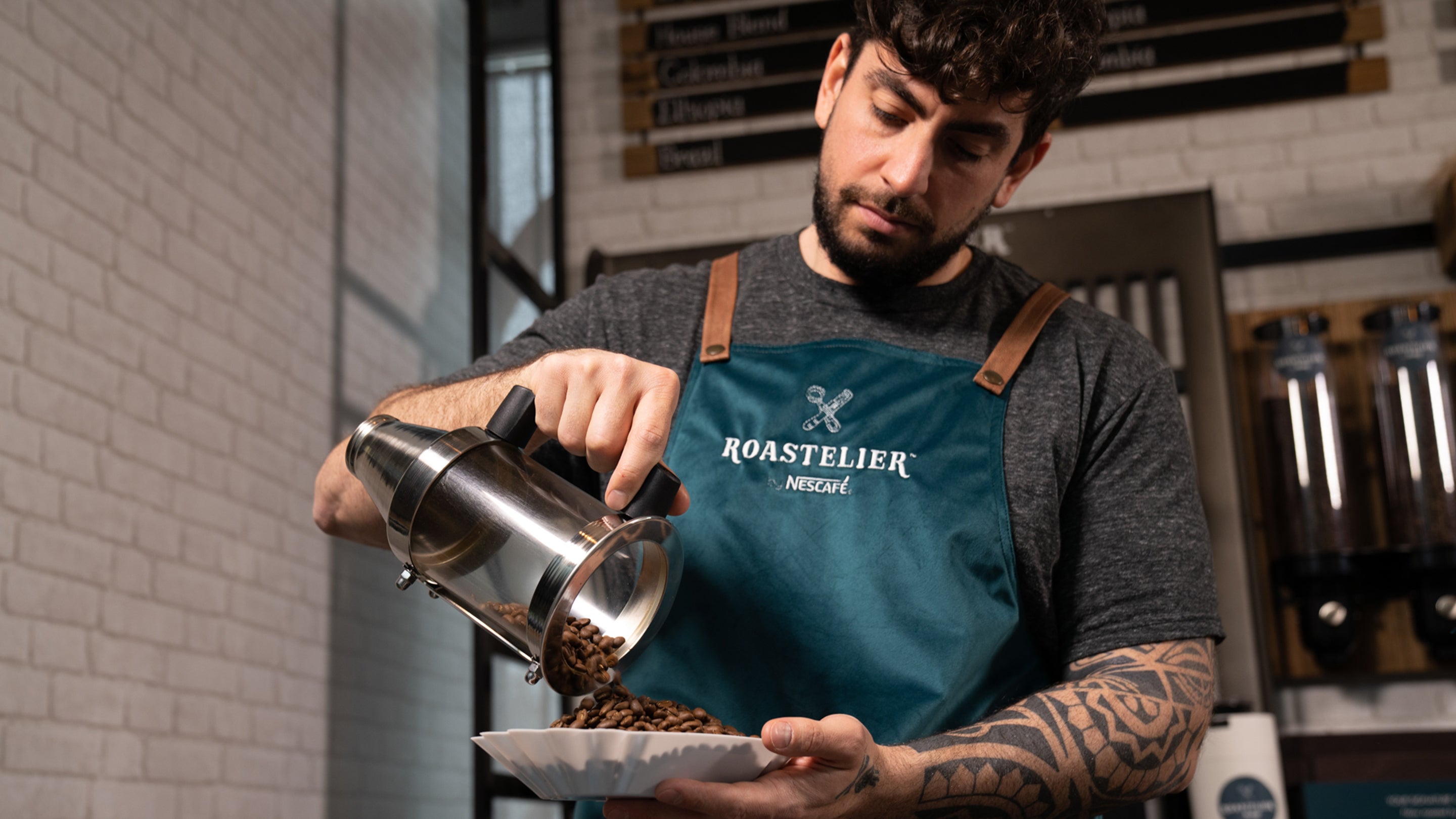 Koffiemedewerker schenkt ROASTELIER gemalen koffie in