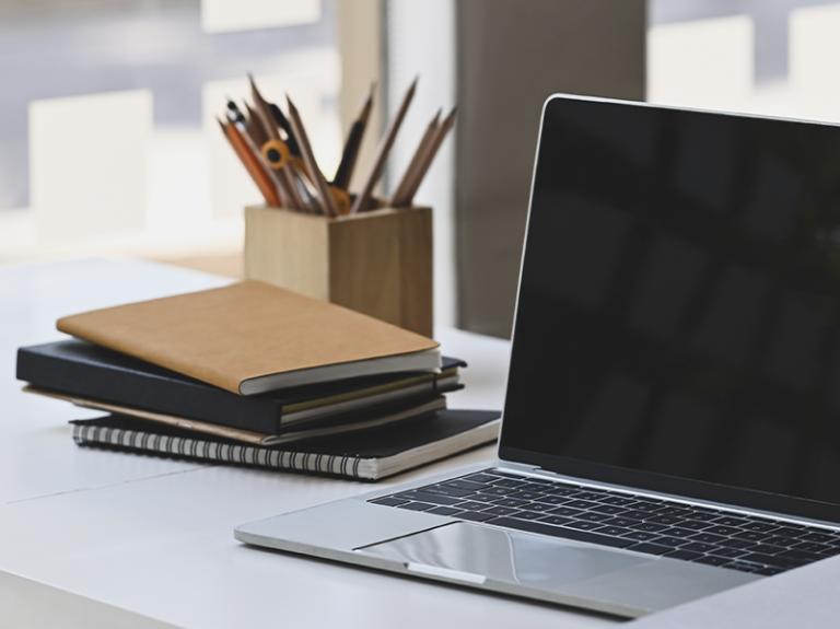 Laptop op bureau met notitieblokken ernaast - Nestlé Professional