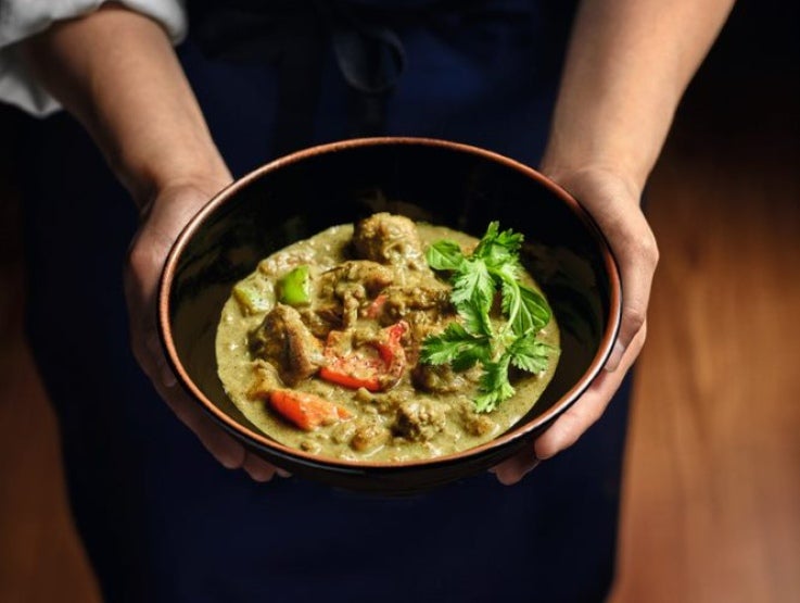 Handen houden een bord met curry vast - Nestlé Professional
