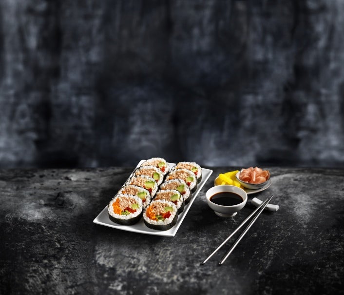 Sushi op een bord met eetstokjes op een donkere achtergrond