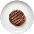 Een hamburger op een witte plaat met sesamzaadjes
