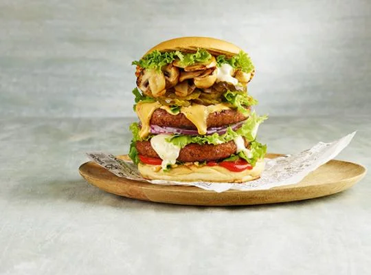 Een champignon burger op een houten bord