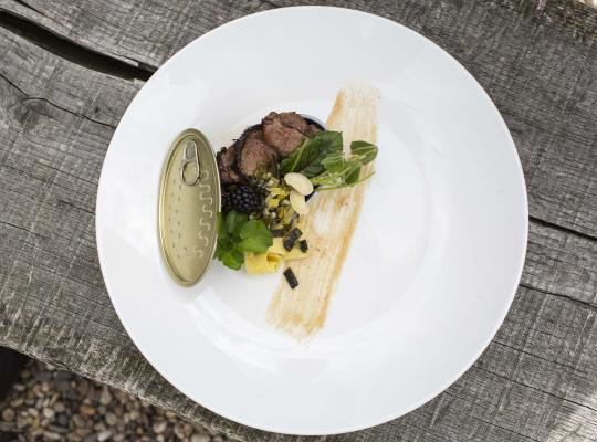 Een wit bord met eten en een blikdeksel 