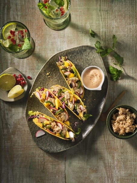 Een bord taco's en drankjes op houten tafel