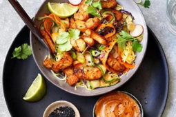 Kom saté op een zwart bord op grijs oppervlak