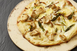 Veganische witte pizza op een bord op een zwarte achtergrond