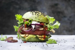 Een hamburger gegarneerd met groente, sla en sesamzaadjes