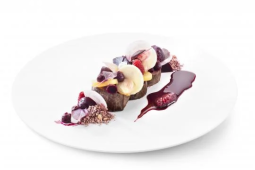 Wit bord met vlees gerecht en rode vruchten