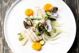 Een wit bord met vlees en groenten