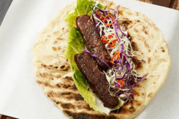 Lamb Kebab op een pitta geserveerd op een vierkant bord