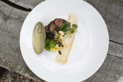 Een wit bord met eten en een blikdeksel