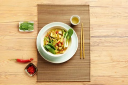 Thaise groene curry in een witte kom op een bruine placemat