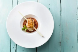 Een wit bord met een visgerecht