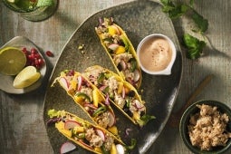 Een bord taco's en drankjes op houten tafel