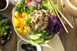 Tonijnsalade in een kom met hakstokken op een houten oppervlak