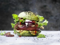 Een hamburger gegarneerd met groente, sla en sesamzaadjes