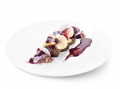 Wit bord met vlees gerecht en rode vruchten