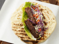 Lamb Kebab op een pitta geserveerd op een vierkant bord